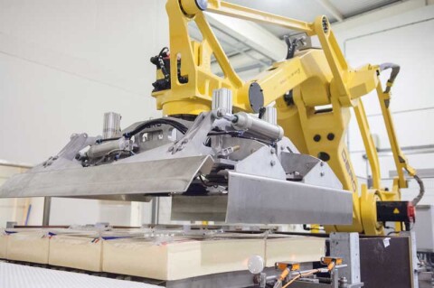 Industri&euml;le robot met gripper voor foliekaas plaatsen in kisten