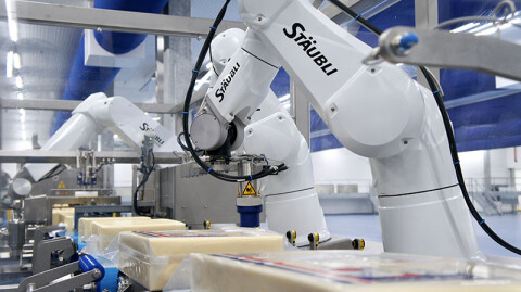 Robots verwijderen de folie van kazen voor toevoer naar de slicer