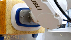 Met een St&auml;ubli robot word de korst van rechthoekige kaas verwijderd