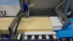 Foliekaas wordt in twee staven gesneden voor aanvoer naar de slicer